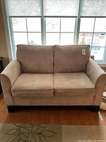 Front view showing two seat cushions, two back cushions and wood legs