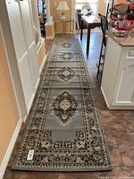 Full length view of the gray runner rug laid out on floor showing its entire design and length.