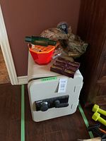 Sentry safe with coin sorter and coin wrappers placed on top, showing overall lot contents.