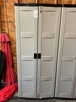 Front view of closed resin storage cabinet with two doors and integrated handles.