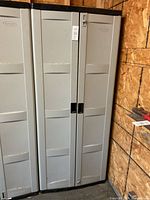 Closed resin cabinet showing double doors with handles and lock mechanism.