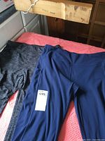 Blue and heather gray stretch pants laid flat to show color and style.