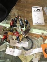 Image showing eight British tin soldier figures arranged on glass surface.