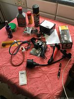 Photo showing various car care and accessory items laid on a table, including dash cam, air pump, fluids, and holders.