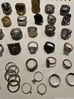 Multiple fashion rings of different sizes and styles arranged on a white background.