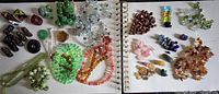 Overview of all beads and toggles laid out in groups on white and notebook pages showing variety of stones and colors