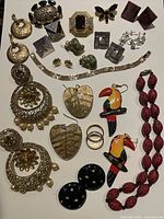 Overview of multiple vintage jewelry pieces including earrings, necklace, bracelet, and brooches