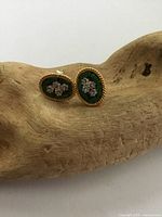 Front view of the pair of vintage micro mosaic flower stud earrings showing detailed floral design on green mosaic background with gold twisted border.