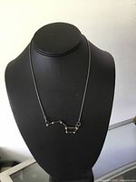 Front view of silver Little Dipper pendant necklace on black display bust showing constellation design.