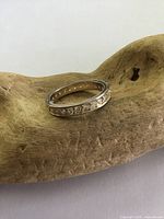 Front angle of sterling silver eternity band showing crystal beads all around the band on a wood-textured surface.