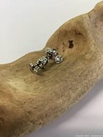 Side view of the 3D sterling silver Mickey Mouse charm displaying hallmark on base and loop attachment.