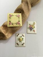 Photo showing three antique sterling silver guilloche enamel plaques arranged on a wooden surface.