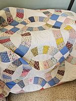 Full view of hand-quilted double wedding ring pattern draped over a surface