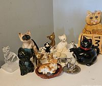 Front view showing most figurines including ceramic cats, brass cats, and black glossy cat teapot