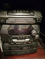 Panasonic stereo system main unit showing 5 CD changer, control buttons, cassette decks, and tuner section