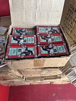 Open box revealing several smaller boxed sets of Monopoly tile magnets, each box labeled 'Set of 4 Tile Magnets' showing Monopoly man illustration.