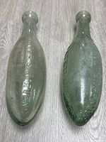 Top view of both antique torpedo bottles showing embossed text and overall shape