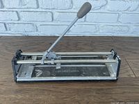 Full view of Blue Hawk manual tile saw showing base, handle, and cutting mechanism.