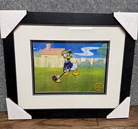 Full view of the framed Donald Duck serigraph showing the artwork and framing with protective corner covers.