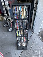Full view of black DVD tower loaded with DVDs