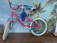 Full side view of pink Girls Mischief bicycle showing frame, tires, pedal, and gel seat