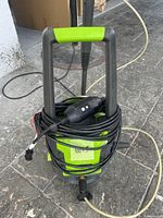 Front view of Greenworks pressure washer showing power cord wrapped around the unit and top handle.