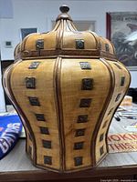 Front view of large wooden ginger jar showing body shape and metal square accents.