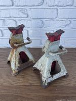 Two metal jack stands, white with red tops, showing rust and wear.
