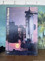 Front view of the oversized poster showing the Space Shuttle on the launch pad at sunrise or sunset with 'Going to Work in Space' text.