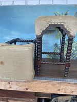 Pair of wooden barstools with burlap fabric seats; one stool's seat detached and placed on side showing fabric condition and frame detail.