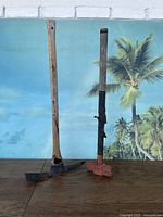 Full view of pickax and sledgehammer standing upright with tropical background