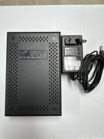 Top view of Seagate Expansion external hard drive and UK style power adapter on a neutral surface