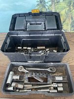 Photo showing the open toolbox with ratchets, wrenches, sockets and wrench extender arranged inside