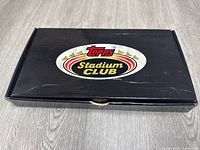 Closed black factory box with Topps Stadium Club logo on top.