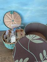 Open view of round snap-top sewing box showing various sewing accessories organized inside compartments.