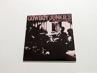 Front cover of Cowboy Junkies The Trinity Session album showing band image and title.