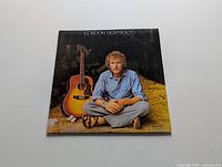 Front cover of the Gordon Lightfoot Sundown vinyl LP showing artist seated with acoustic guitar.
