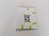 White binder with Pokémon card back image taped on front cover.