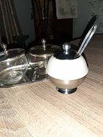 View of the milk glass and aluminum mustard jar with metal lid and plastic spoon next to the vintage preserve jars on the tray.