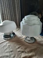 Both Art Deco lampshades shown together on a table under natural light.