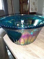 Photo showing the overall iridescent depression glass punch bowl with scalloped rim and colorful sheen on the surface