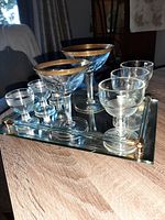 Overall view of vintage glassware and glass bar tray on wooden surface