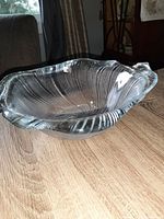Side view of the clear vintage crystal bowl showing scalloped edges and swirl texture pattern reflecting light