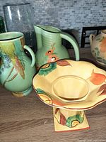Three vintage pottery pieces: 1 pitcher and 2 vases with floral designs