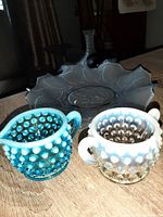 Blue glass hobnail sugar bowl and clear hobnail creamer showing dotted hobnail texture and handles