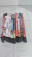 Photo showing the spines of ten DVDs, titles include 'What About Bob?', 'Be Cool', 'Wedding Weekend', 'Happy Gilmore', 'Old School', 'Grown Ups 3', 'Ghostbusters', and others.