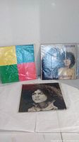 Three vinyl albums displayed: one with colorful geometric cover, two with black and white portrait covers of Marc Bolan, lead singer of Tyrannosaurus Rex.