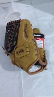 Photo of the tan leather Franklin baseball glove with brown lacing, showing the CFS strap and part of the glove's pocket.