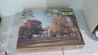 Box of sealed Waddingtons 5000 piece puzzle showing autumn church scene with fall foliage.