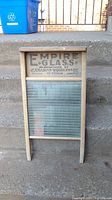 Full view of vintage wooden washboard with the glass scrubbing panel and top branding text.